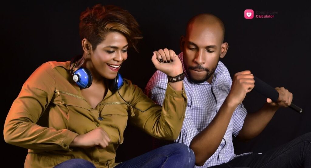 Couple sitting together on a couch, laughing while playing a quiz game on a phone